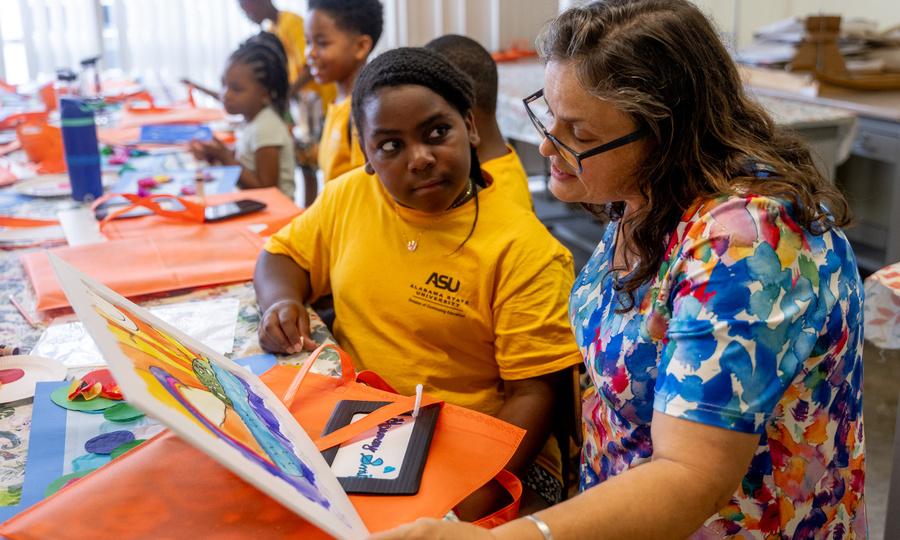 Student in ASU yellow shirt working with teacher