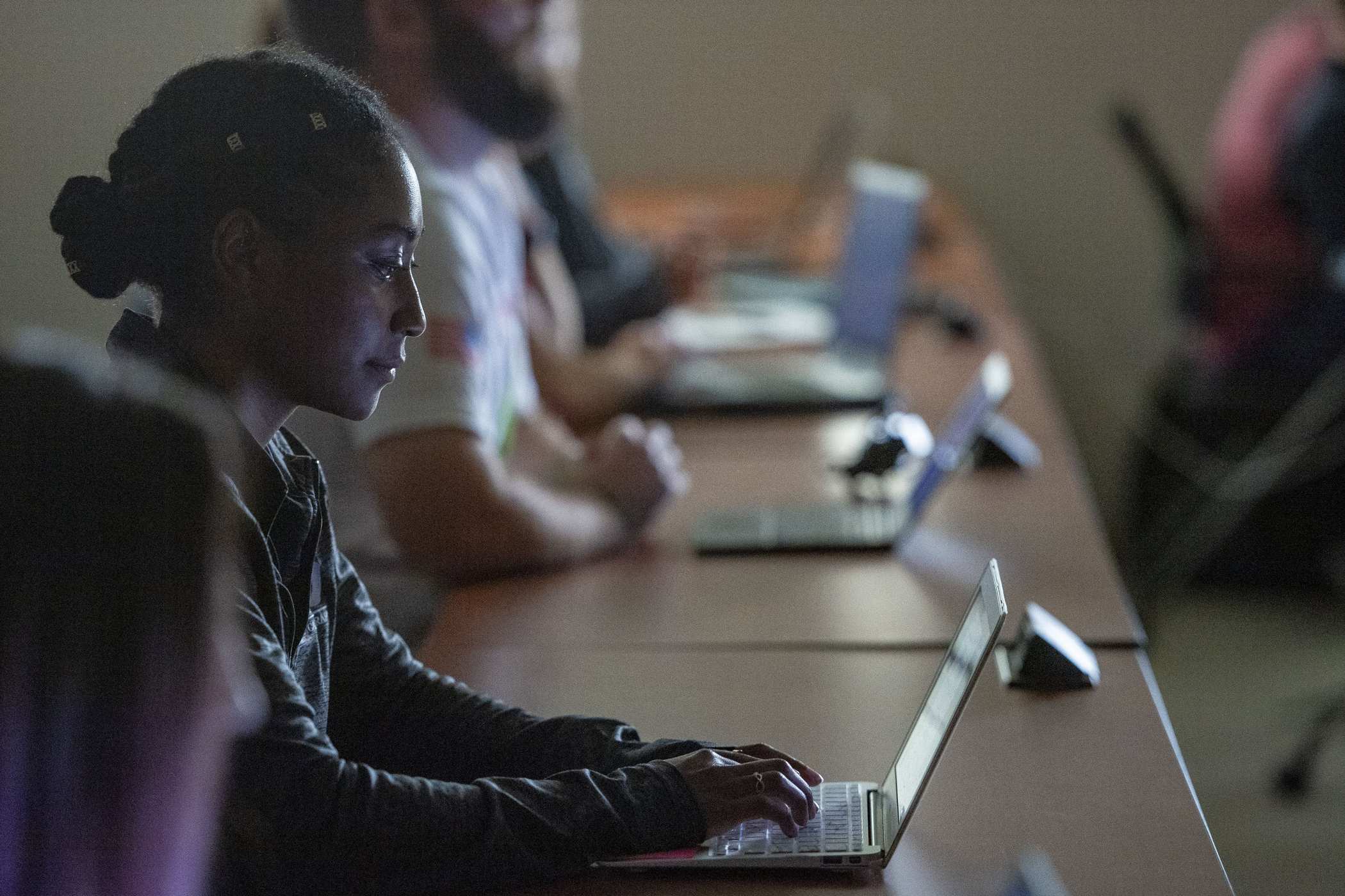Adult students working on laptops in class