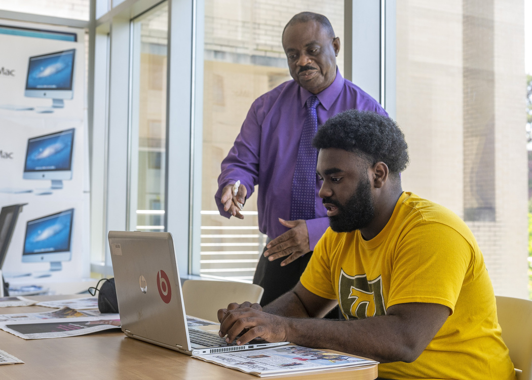ASU teacher and student working on a laptop